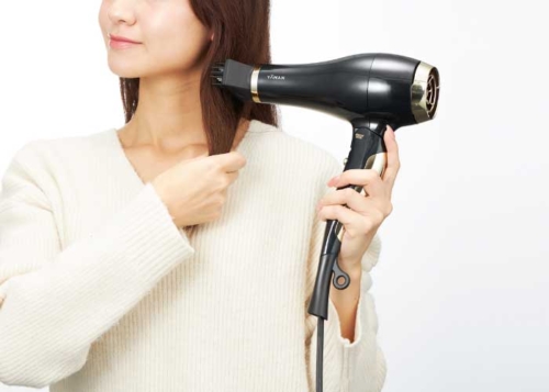 イオンブライトコームで髪を乾かす女性